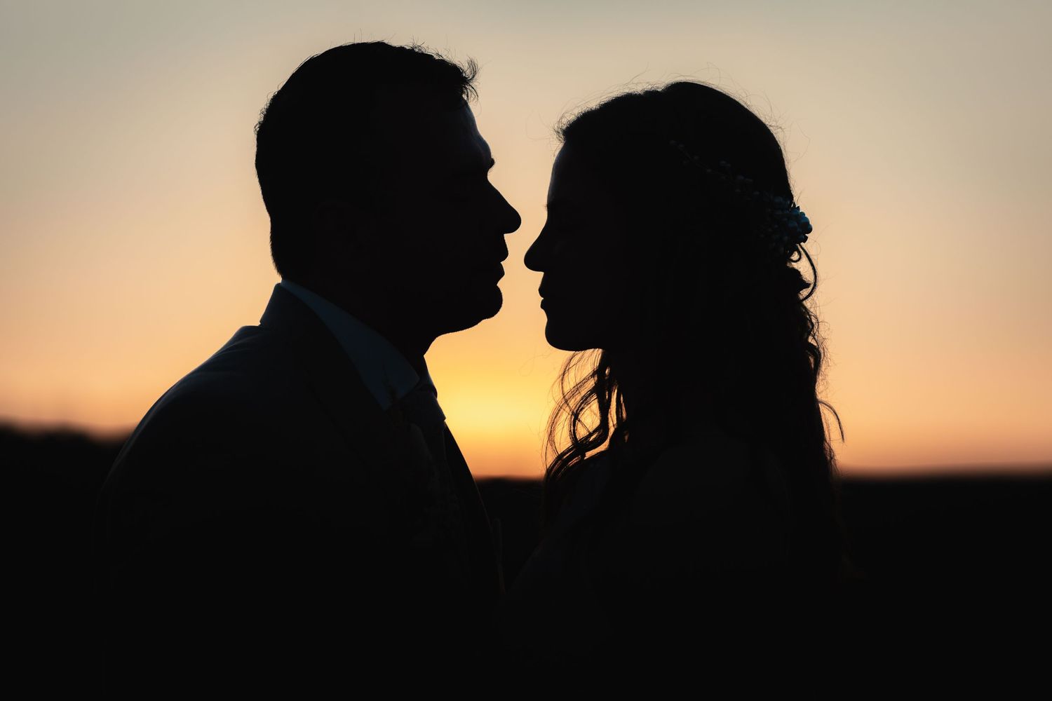 Romantic silhouettes against a sunset sky create a dreamy atmosphere.