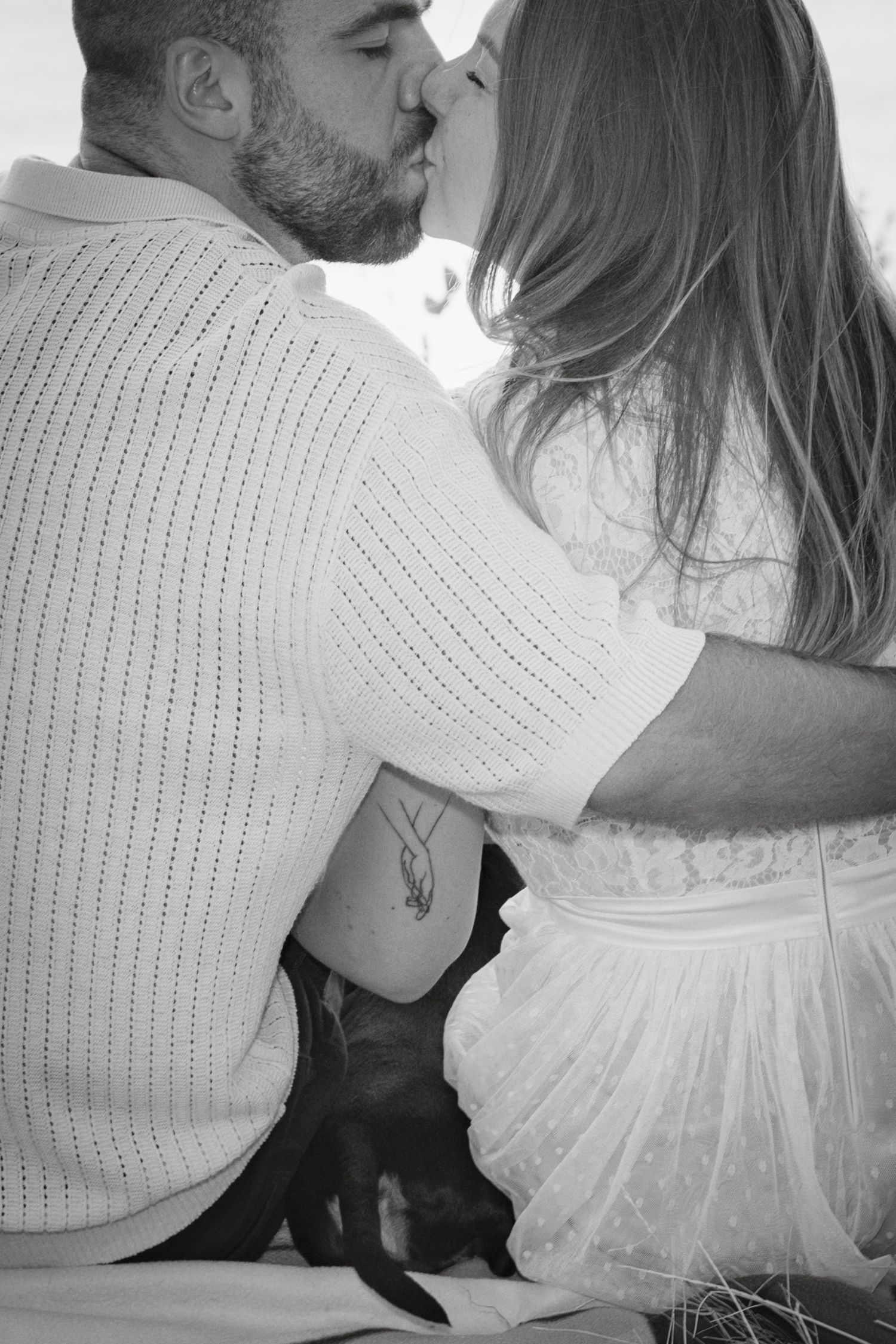 An intimate black and white photo of a couple sharing a tender moment.