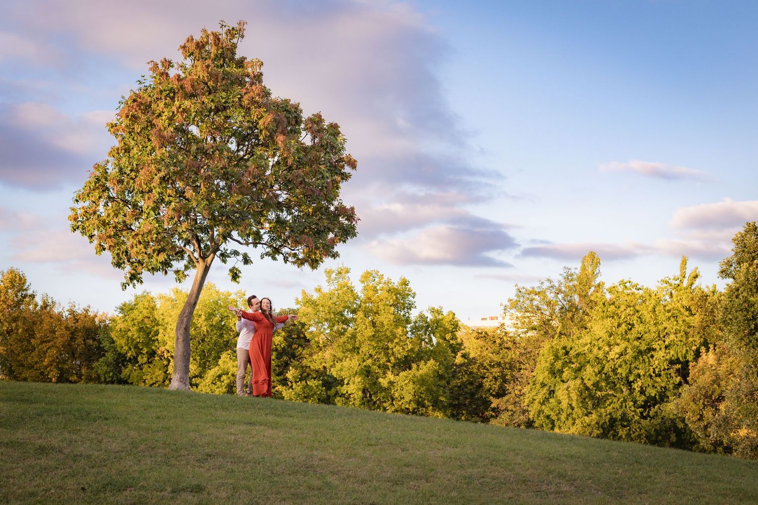 Rolling hills and autumn trees create a peaceful landscape at dusk.