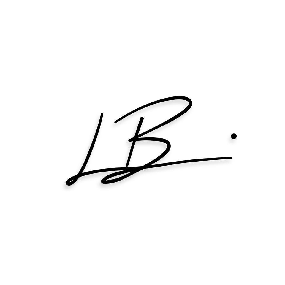 A handwritten signature in black ink appears on a white surface.
