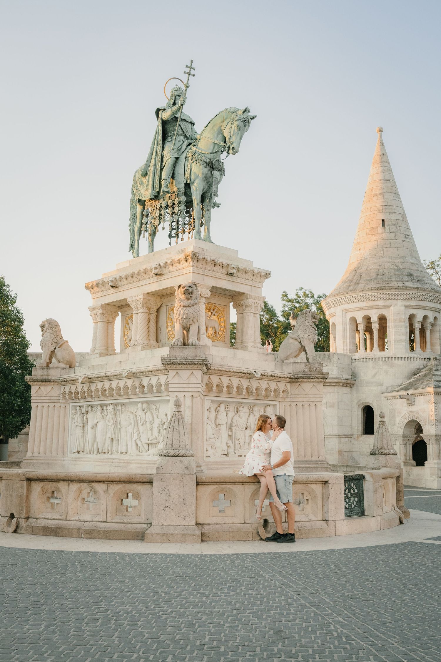 Couple kissing before Saint Stephen equestrian statue at Fisherman's Bastion, Budapest, Hungary.