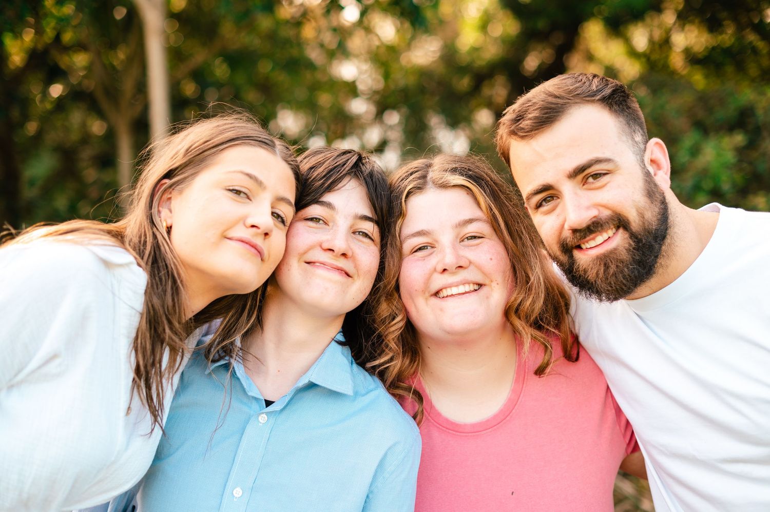Close-up shot of friends sharing genuine laughter during an outdoor photo session.