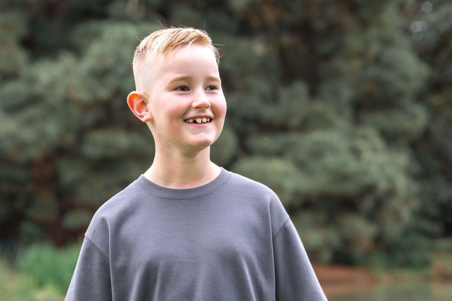 Casual outdoor portrait session with natural lighting and evergreen trees in background.
