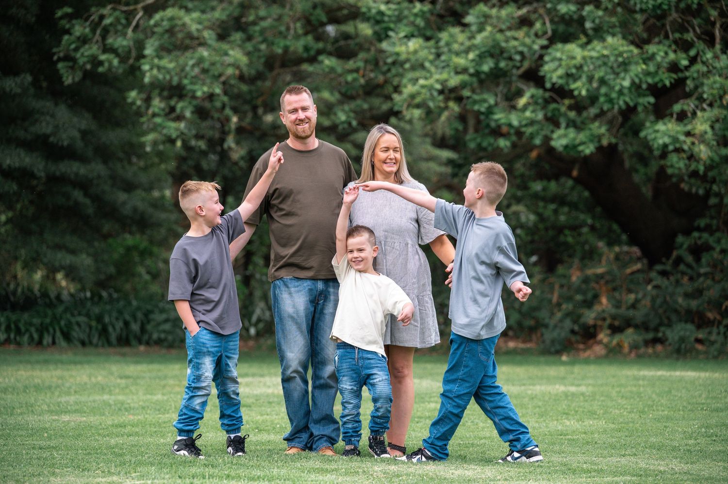 Group photo session in a green park setting with casual coordinated outfits.