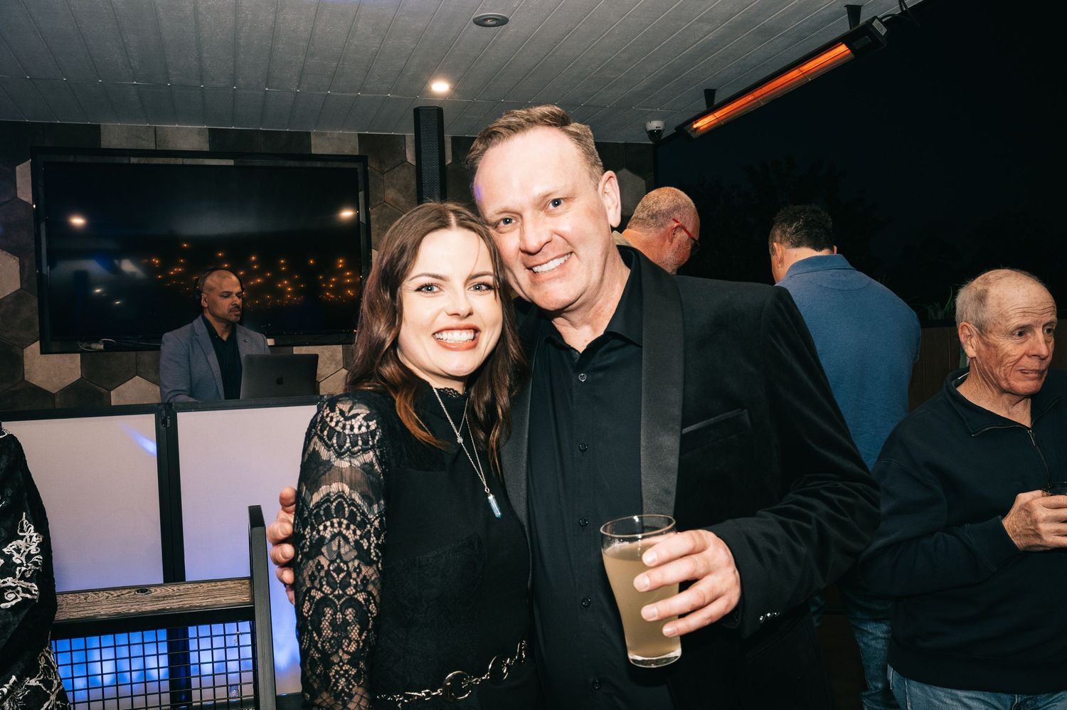 Couple enjoying drinks and conversation at an evening social event.
