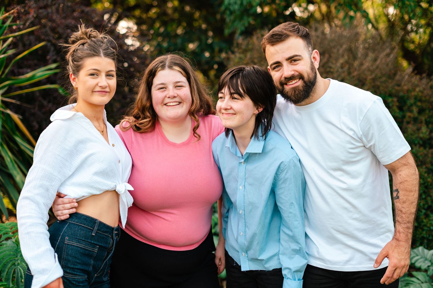 Friends share laughs during an outdoor photo session in coordinated casual wear.