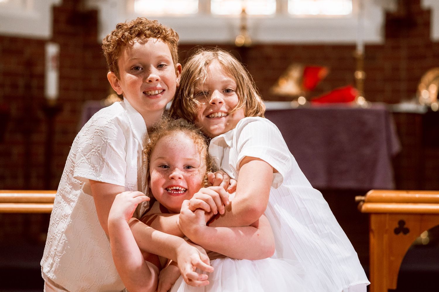 Children in white clothing share joyful moments during church event.