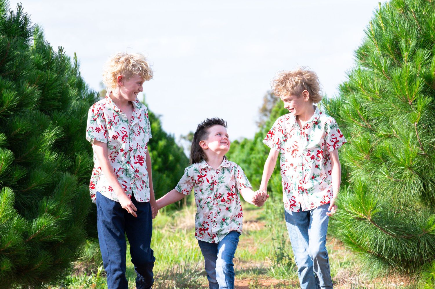 Candid moment between family members in a garden setting wearing matching floral outfits.