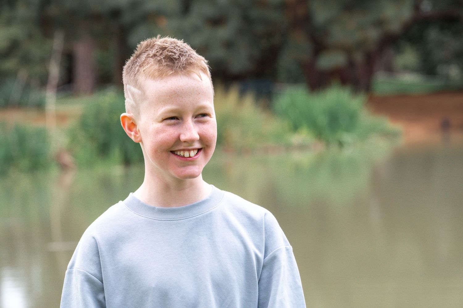 Portrait series by a pond with natural lighting and greenery in background.
