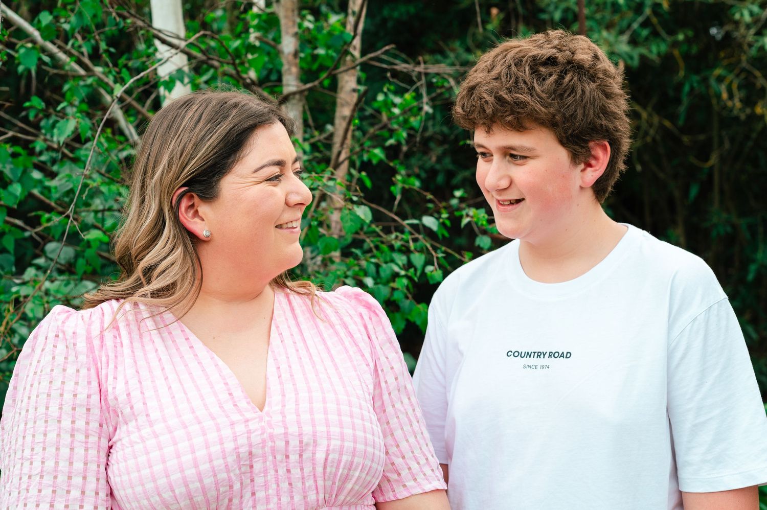 Two people sharing candid moments outdoors in a natural setting.