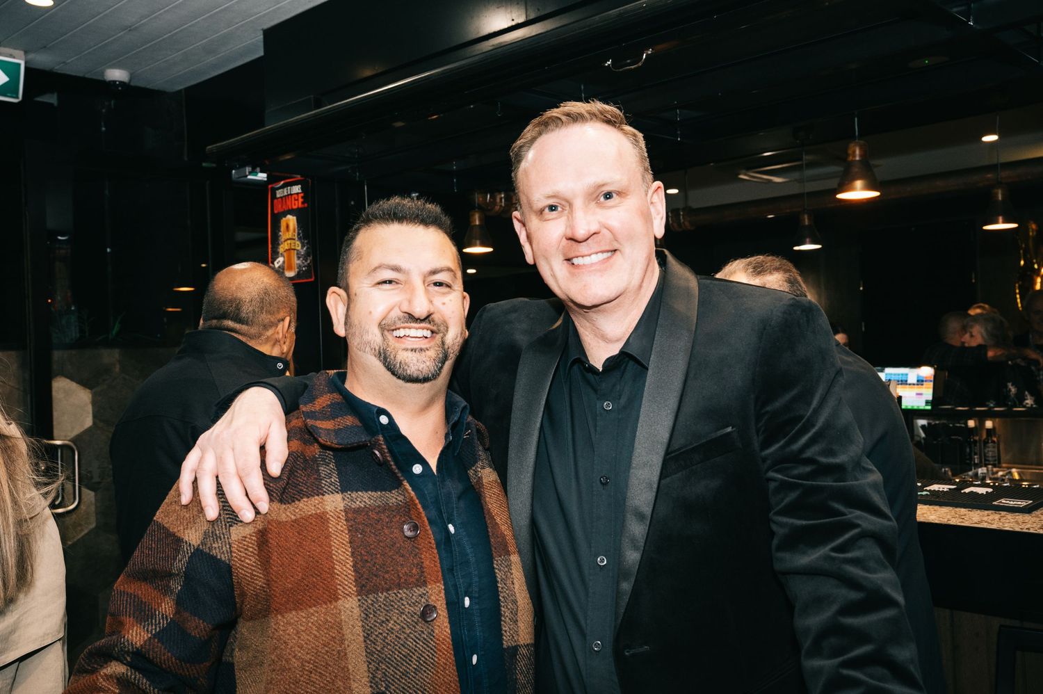 Friends gathered at a dark indoor venue for a celebration.