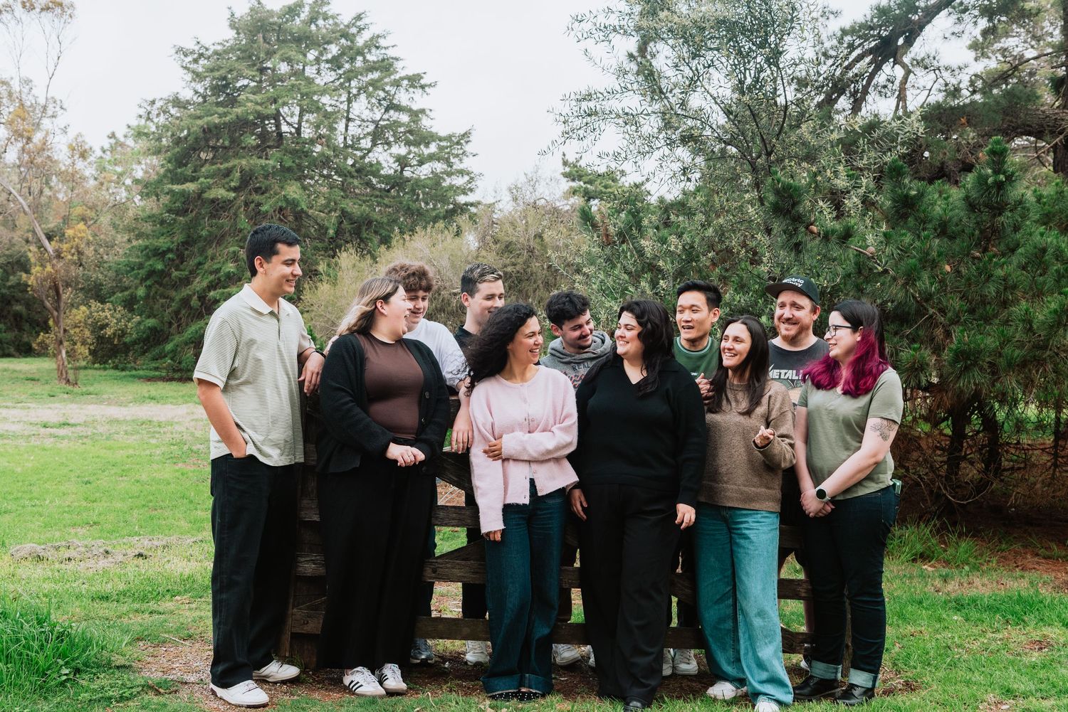 Group photo session in a park with trees and natural landscaping.