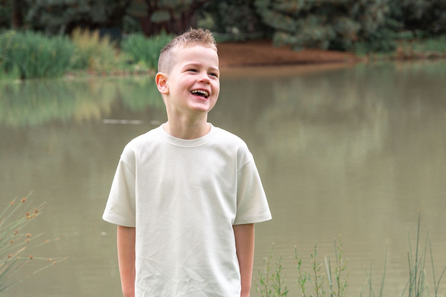 Candid moments captured by a pond with soft natural lighting and summer scenery.