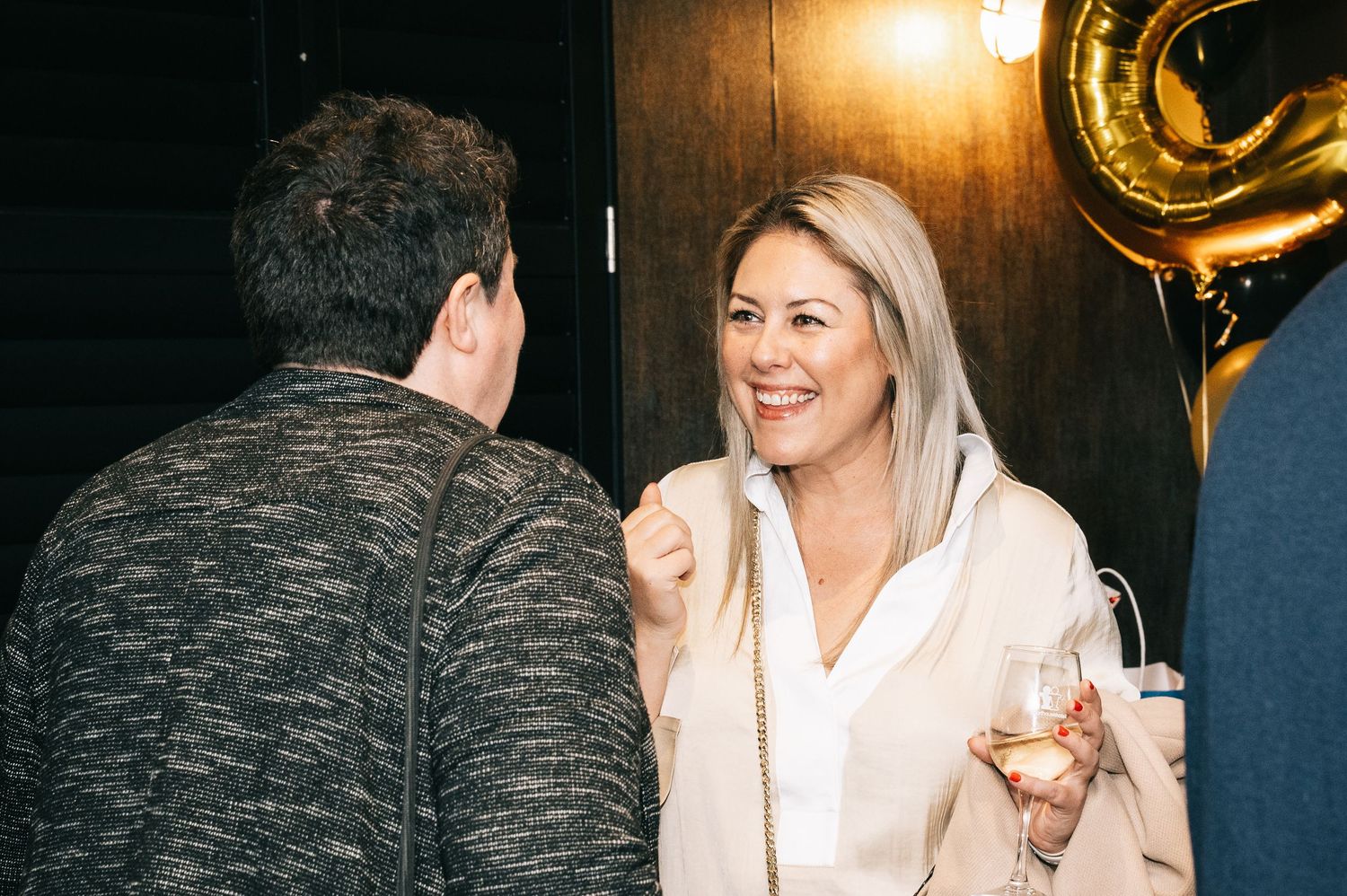 People enjoying drinks and conversation at an evening celebration party.
