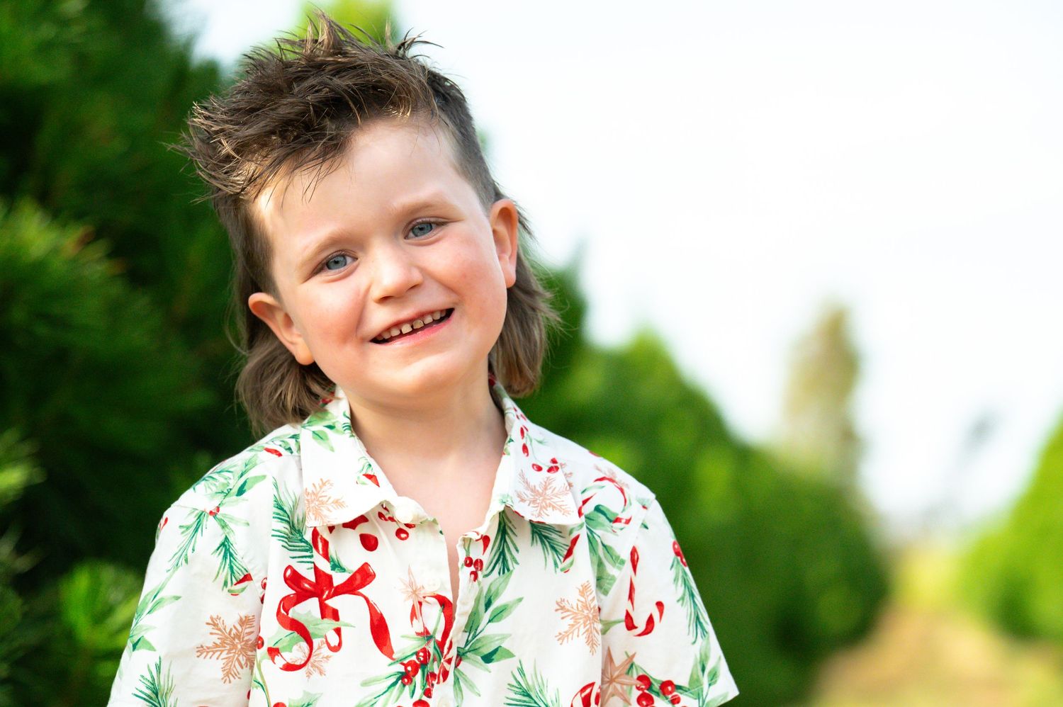 Cheerful outdoor portrait session with matching floral shirts against green foliage.