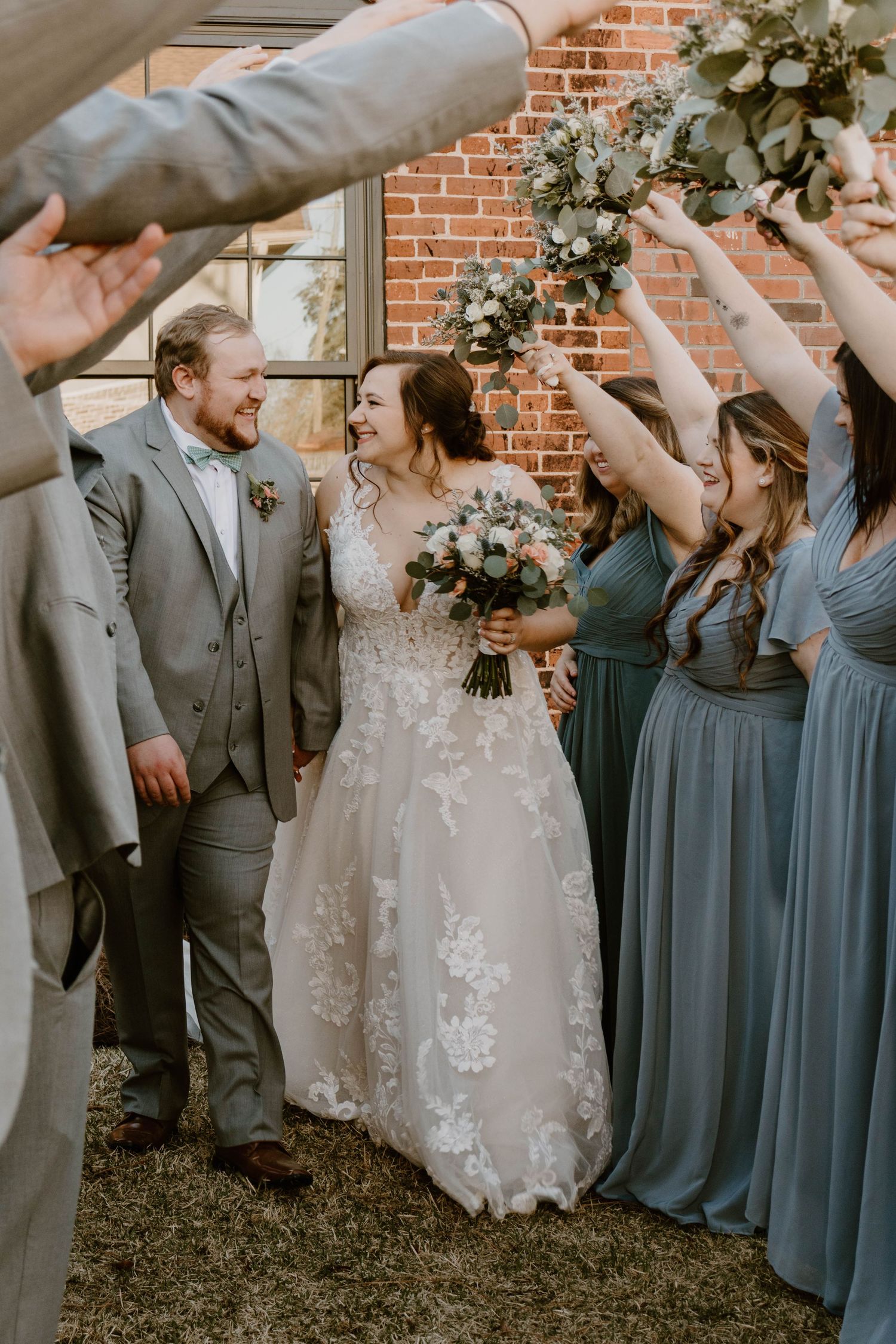 Joyful wedding party celebration shots outside historic brick building.