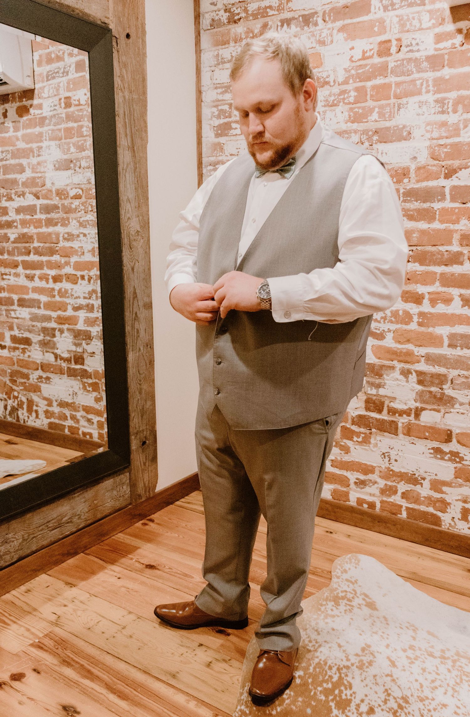 A formal occasion preparation scene in a rustic brick interior setting.