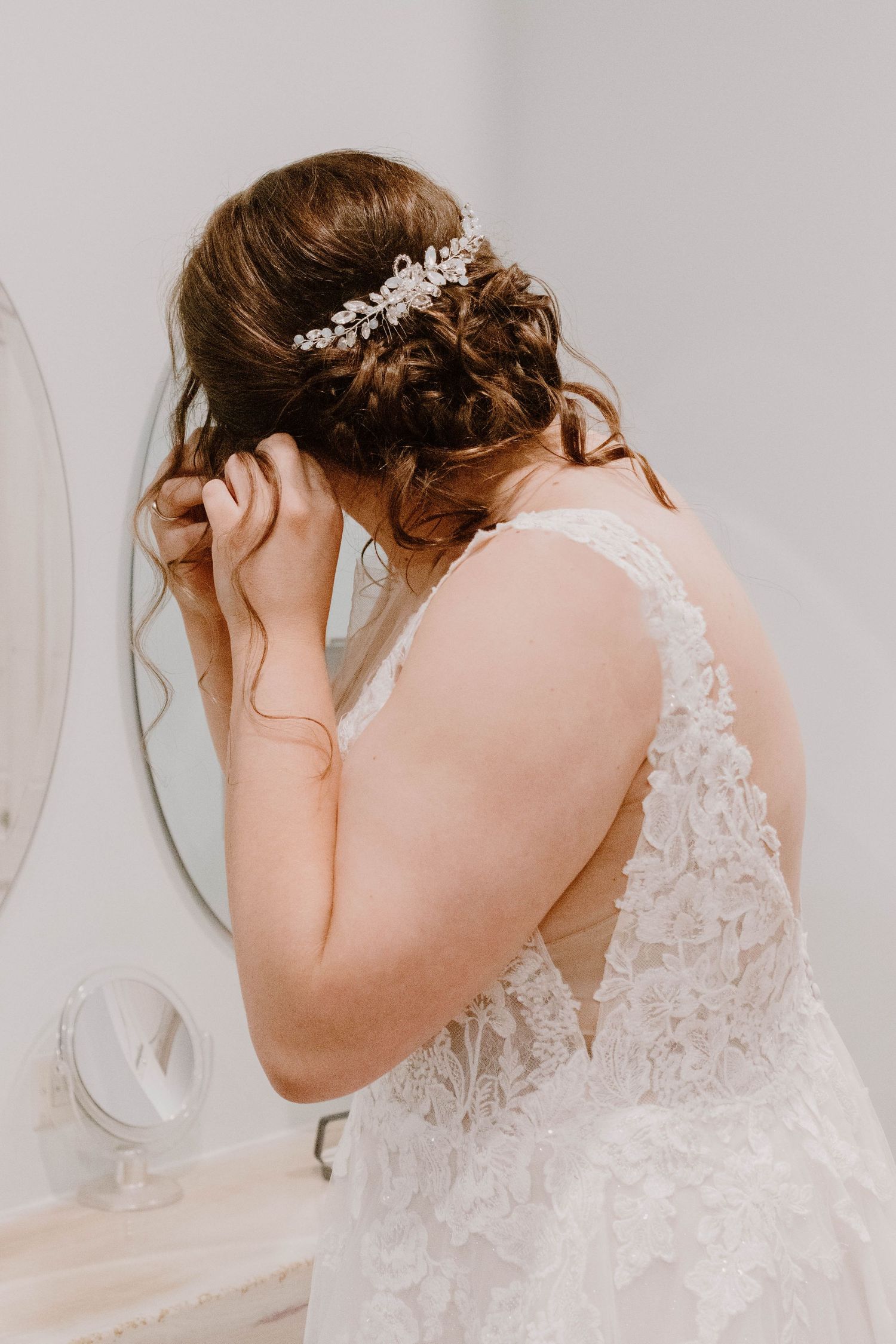 Close-up of delicate lace details on the back of a white wedding gown with crystal accents.