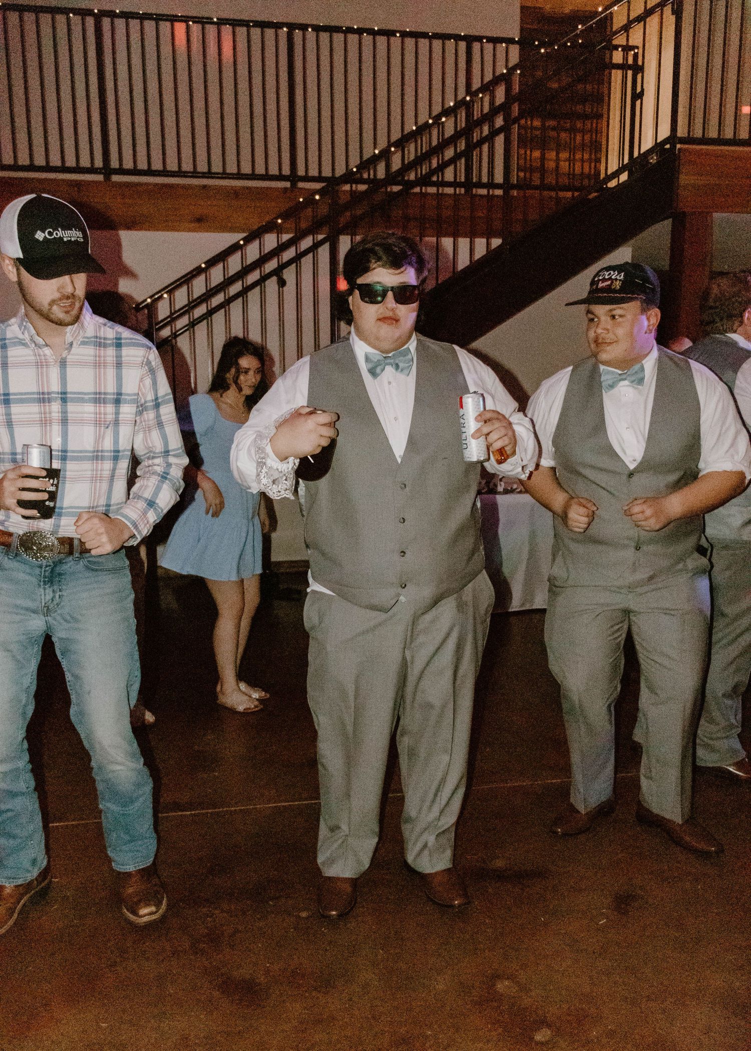 Groomsmen in gray vests line up for a fun dance sequence at wedding reception.