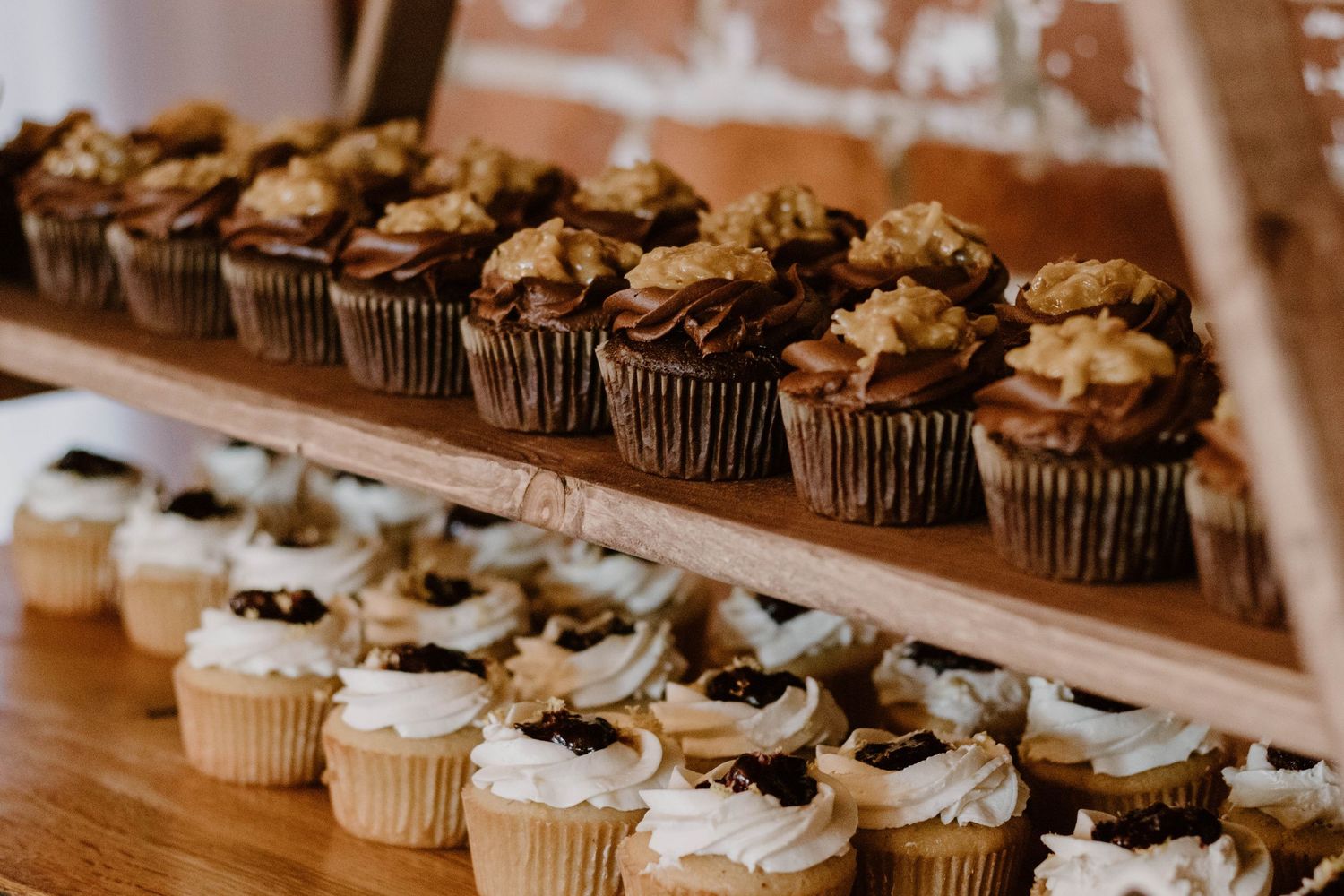 Display of wedding cupcakes arranged in rows with white frosting.