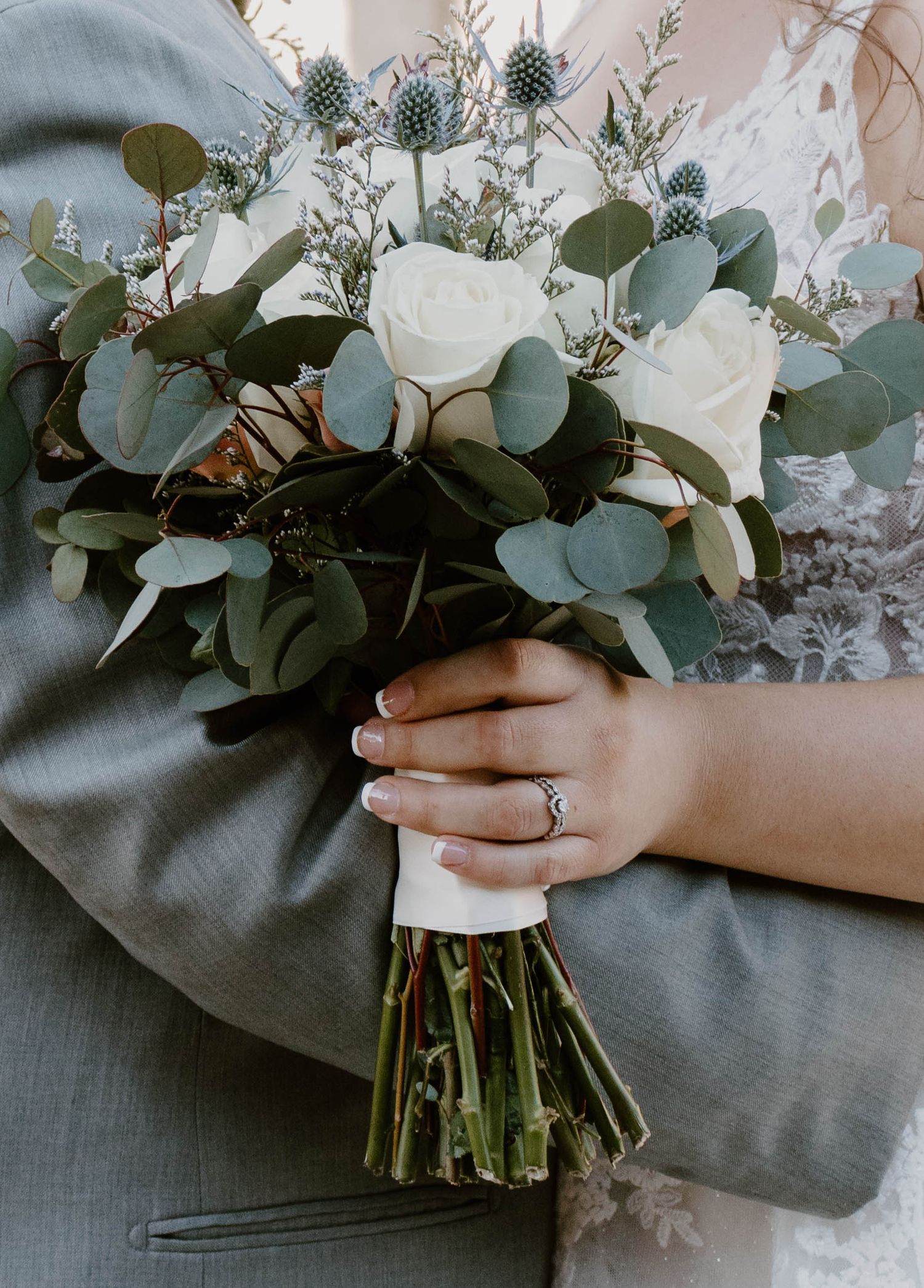 Close-up details of an elegant bridal bouquet featuring white flowers and eucalyptus leaves.