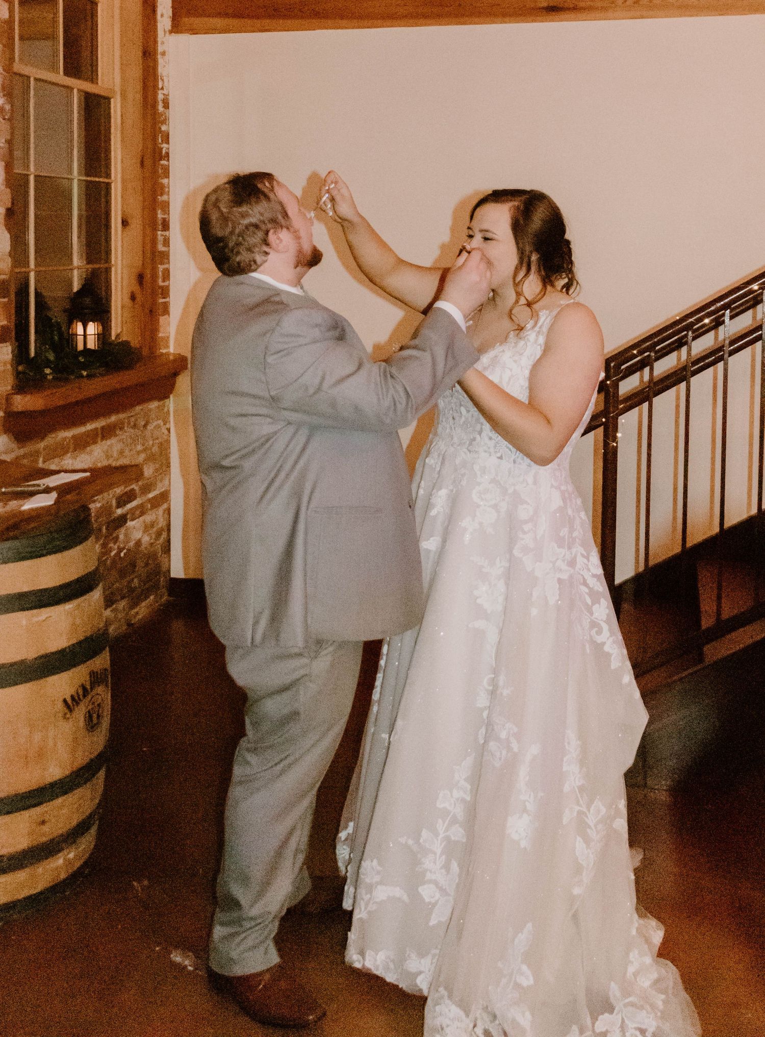 Dancing sequence near wooden barrels showing playful moments at a wedding reception.
