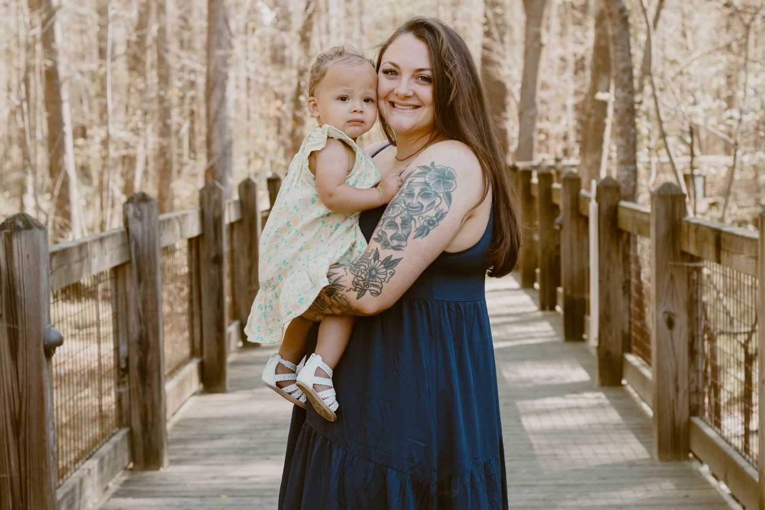 Sweet family moments captured on a wooden boardwalk with forest scenery.