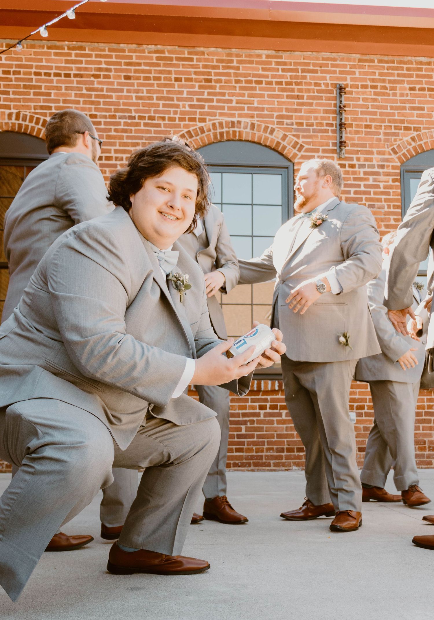 Wedding party members in gray suits strike funny bowling poses in sequence.