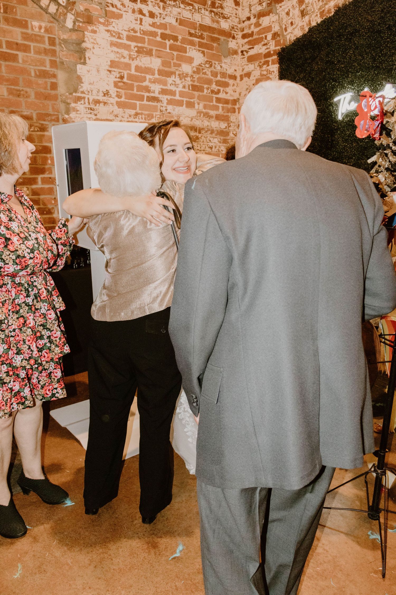Guests socializing at a wedding reception against exposed brick walls.