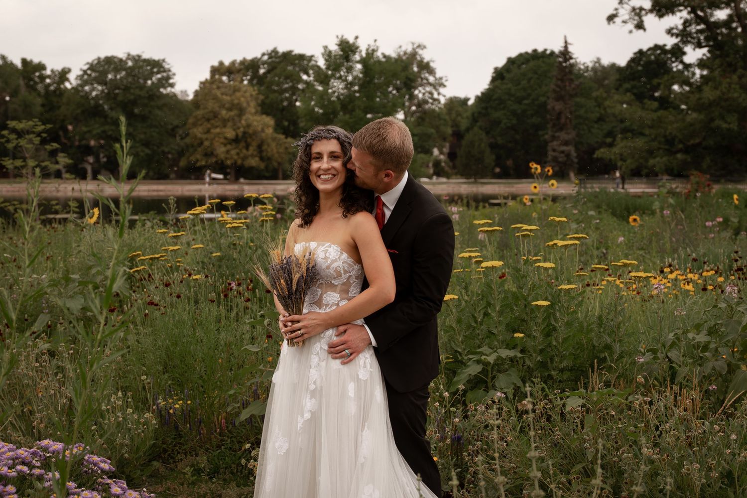 A couple shares intimate moments in a wildflower meadow during their wedding photo session at sunset.