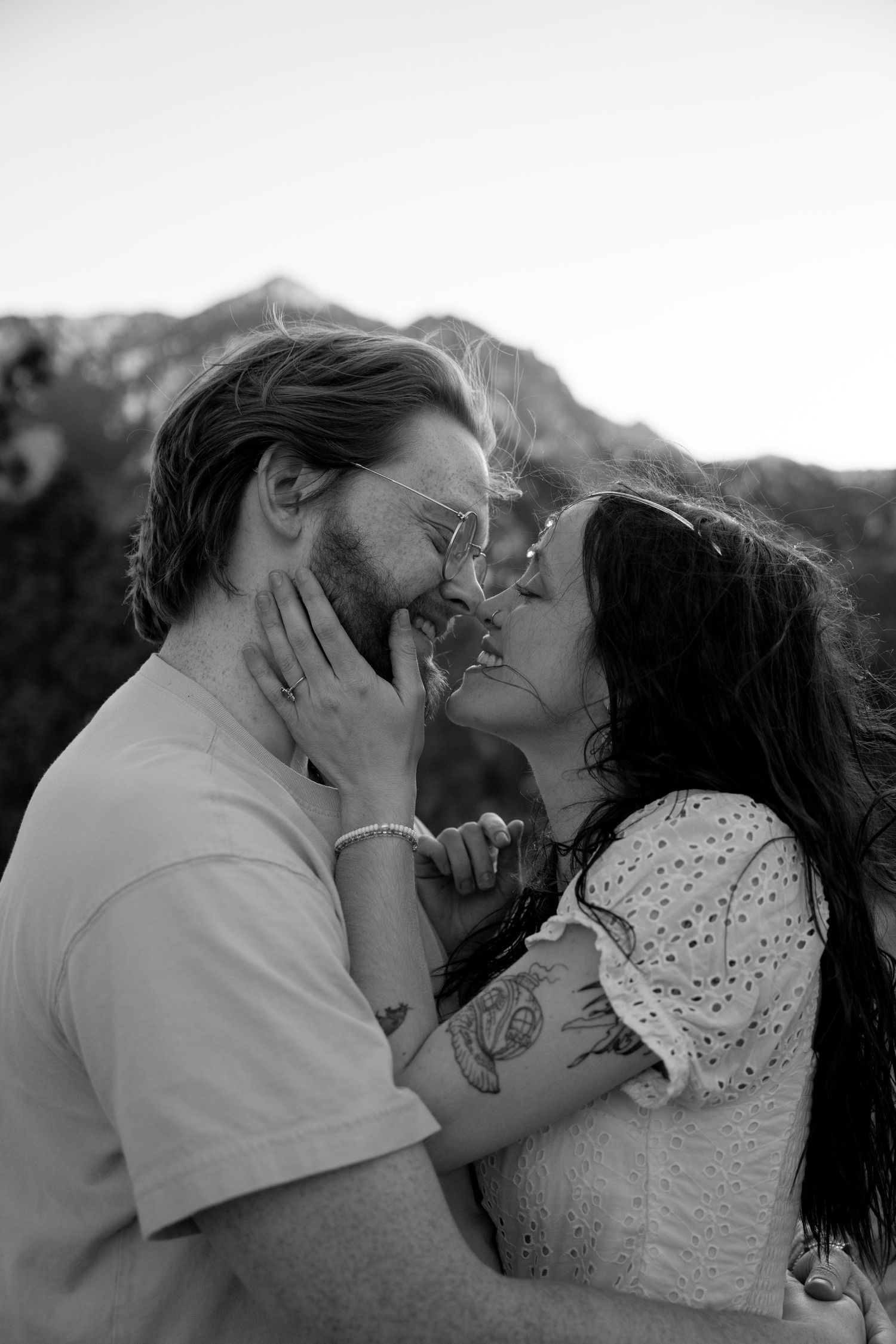 Black and white romantic portrait of couple sharing intimate moment outdoors.