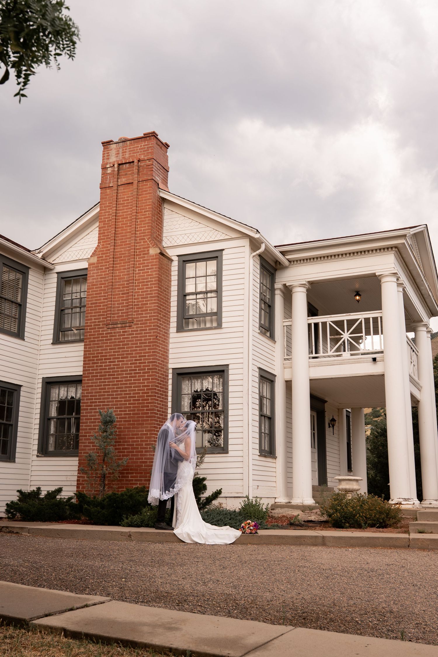 Classic white colonial style wedding venue with brick chimneys and pillars.