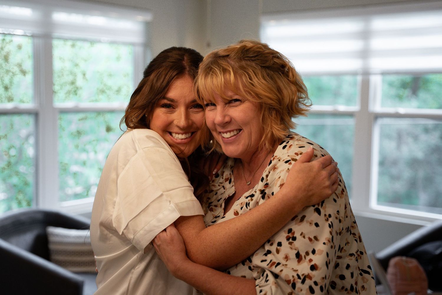 Bride to be hugs her mom as they're getting ready for the wedding.