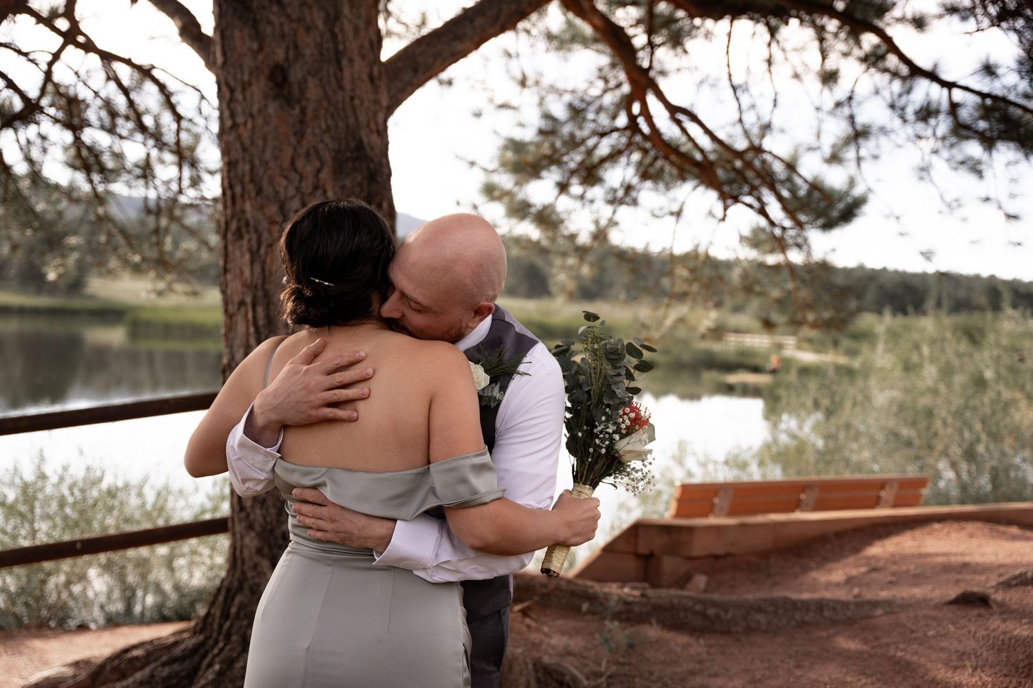 A romantic couple embraces during a rustic outdoor photo session in a natural setting.