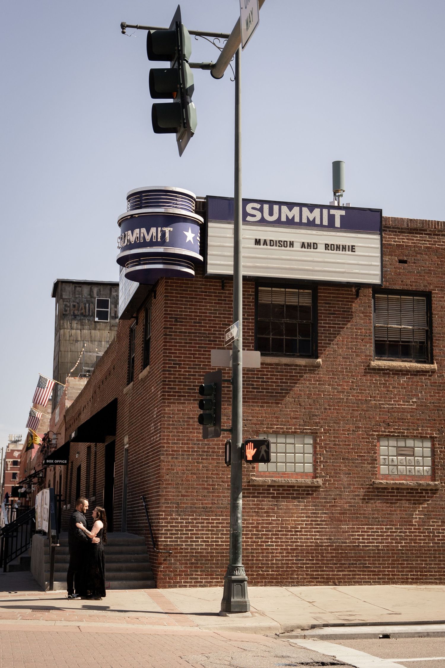 A brick building with Summit signage and traffic lights against a blue sky.