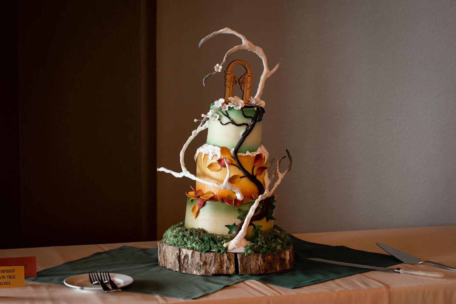 Creative wedding cake decorated with woodland-themed elements and climbing figurines.