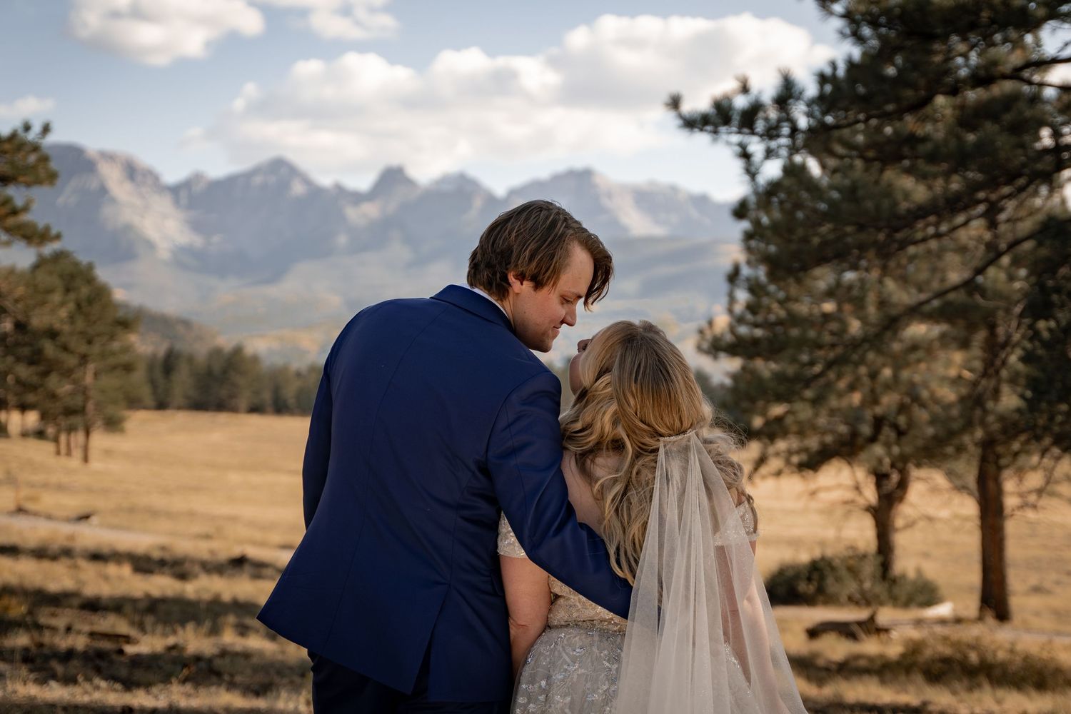 Couple embraces against a stunning mountain backdrop during their wedding photoshoot.
