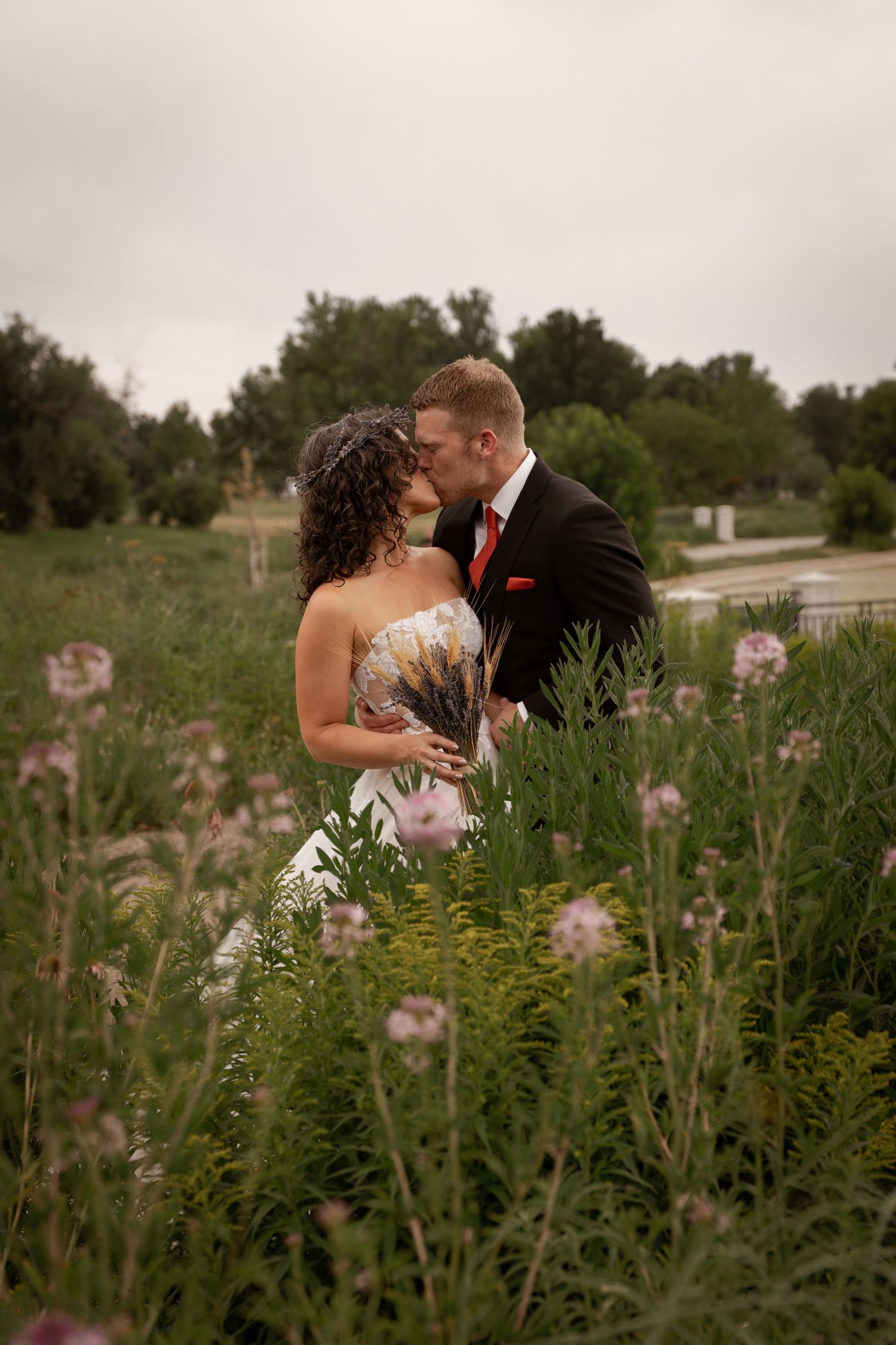 A romantic couple shares intimate moments in a wildflower field during their wedding photo session.