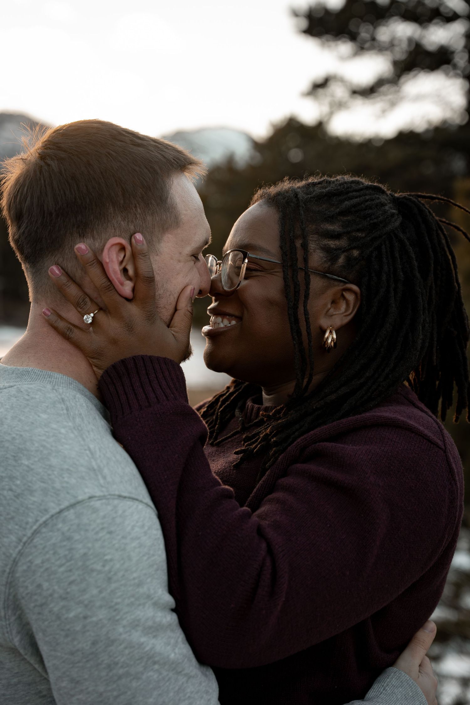 An intimate moment between a couple sharing laughter outdoors at sunset.