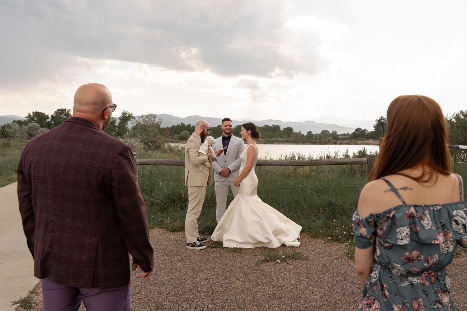 Wedding couple shares intimate moments along a scenic lakeside path during golden hour.