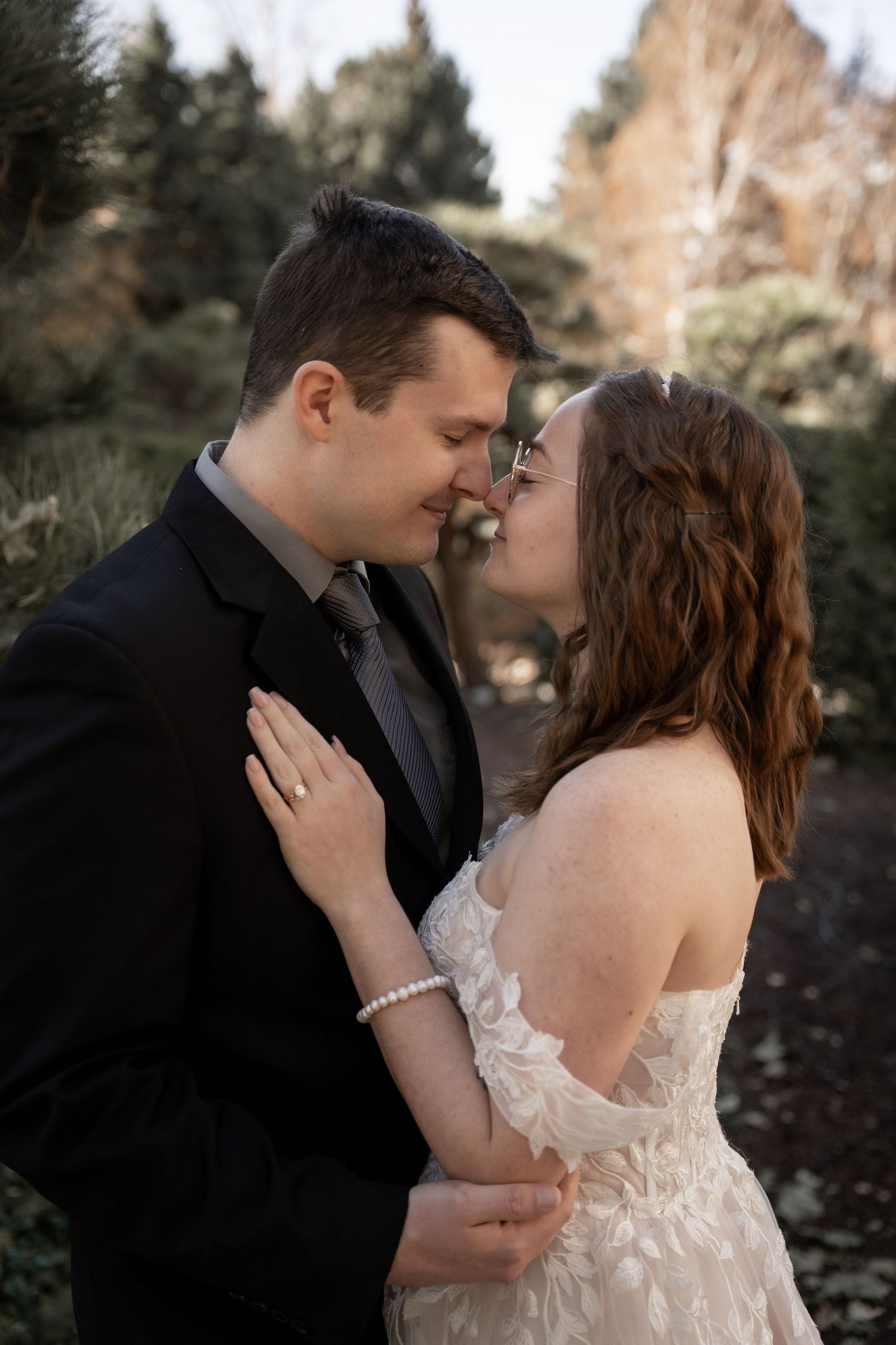 Intimate wedding portrait showing tender moment between couple against natural rock formations.