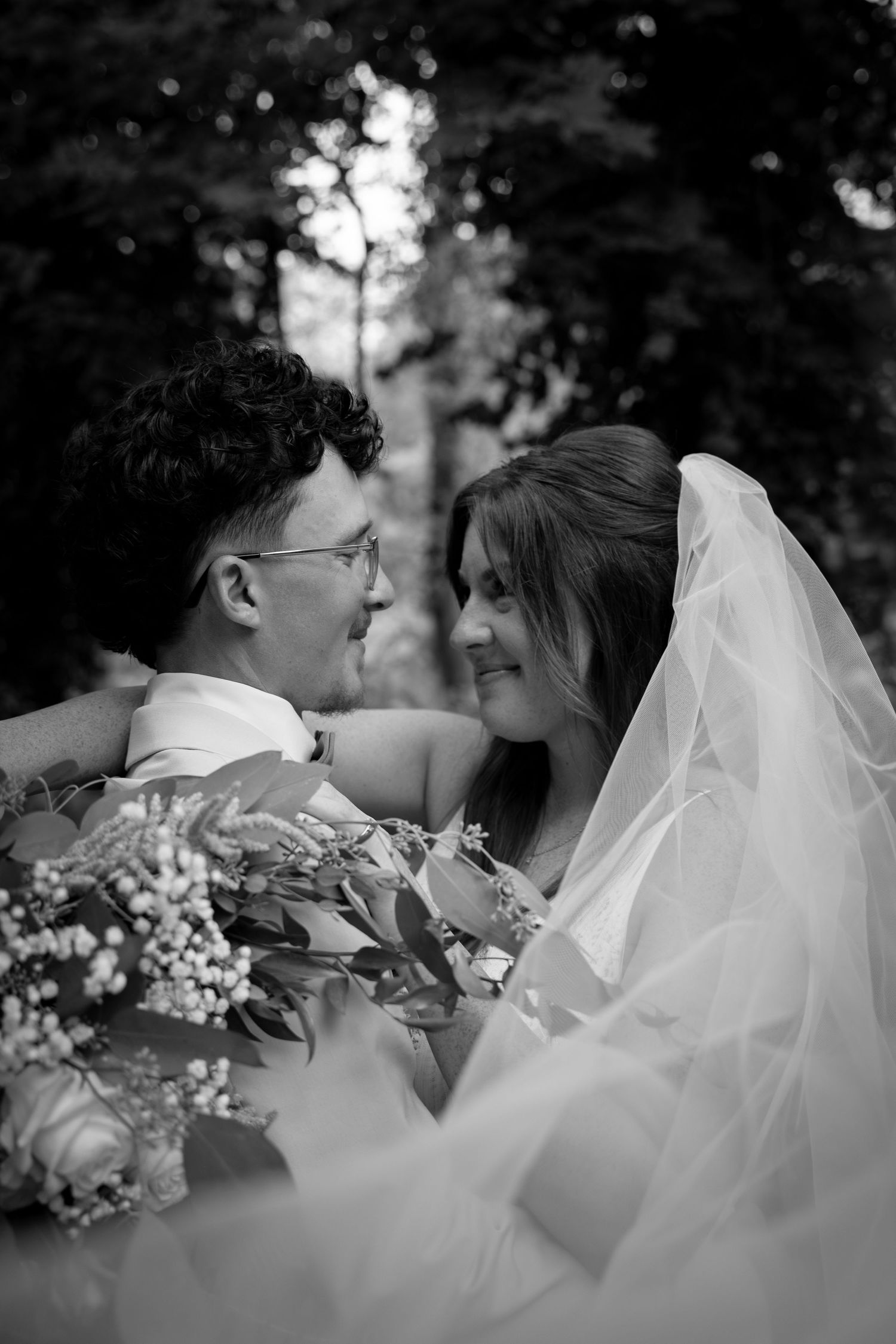 Intimate black and white wedding portraits with floral bouquet details.