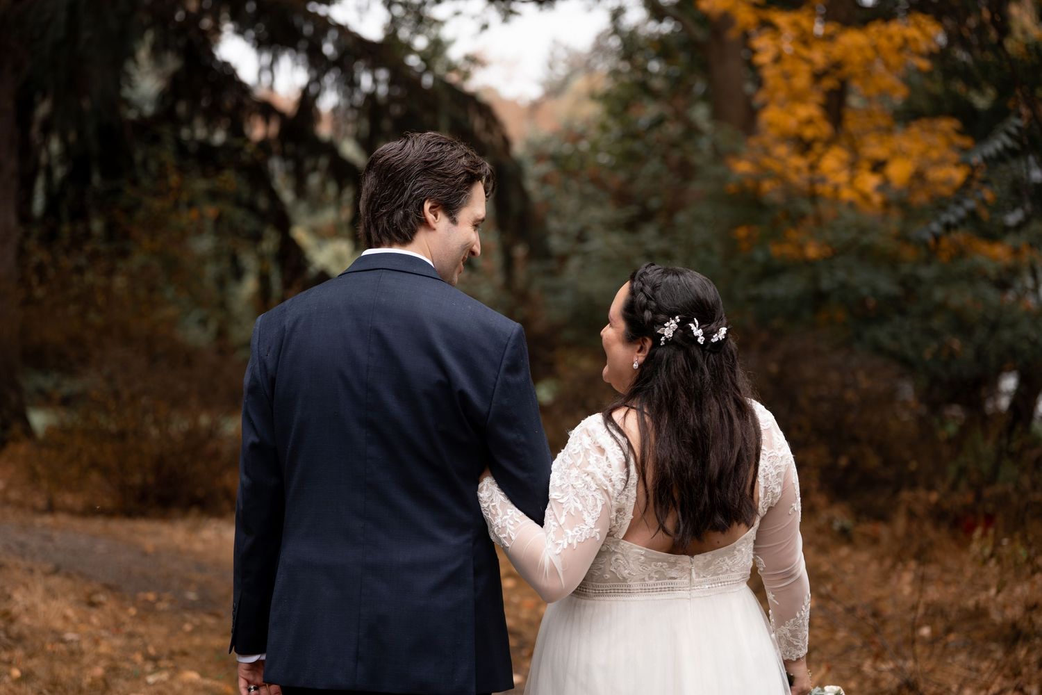 Romantic autumn wedding photos captured in a wooded setting with warm fall colors.