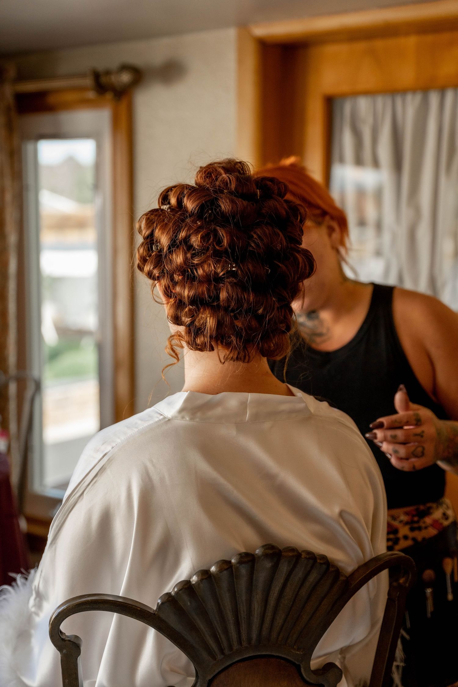 A sequence of photos showing someone with curly red hair getting ready in a white robe from behind.