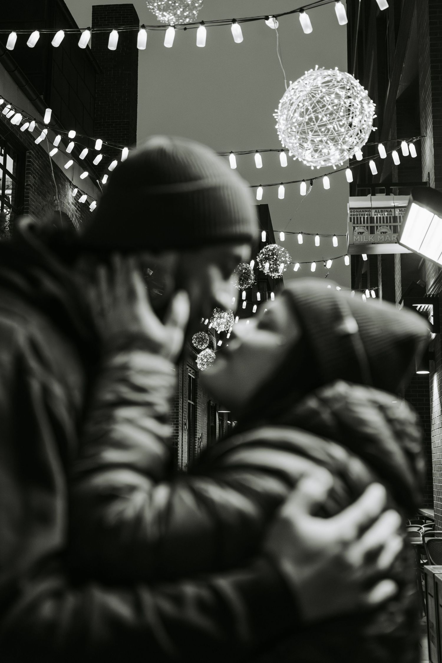 Atmospheric black and white photo with string lights and illuminated decorations.