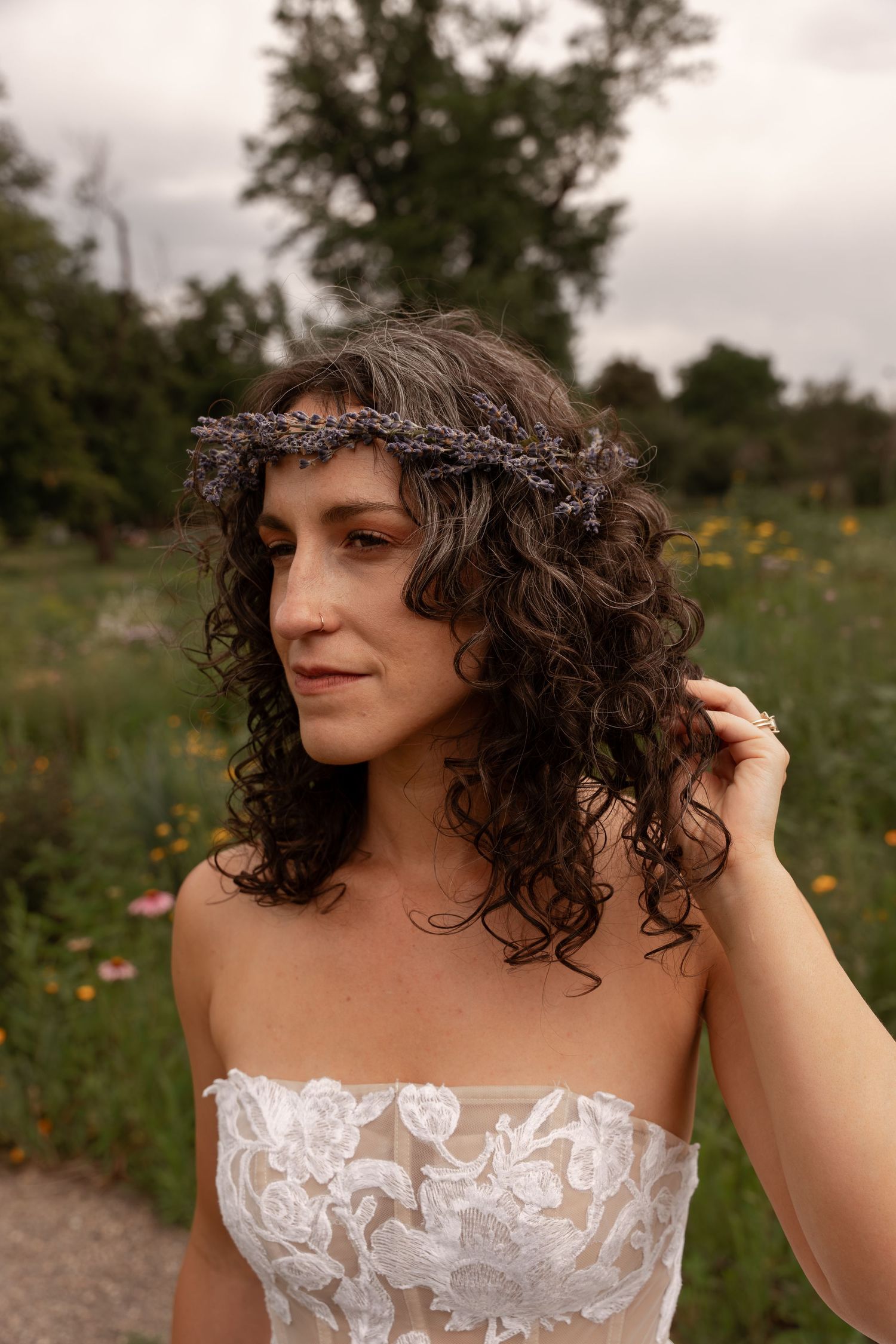 A series of photos showing someone with curly dark hair wearing a white strapless dress in a natural outdoor setting.