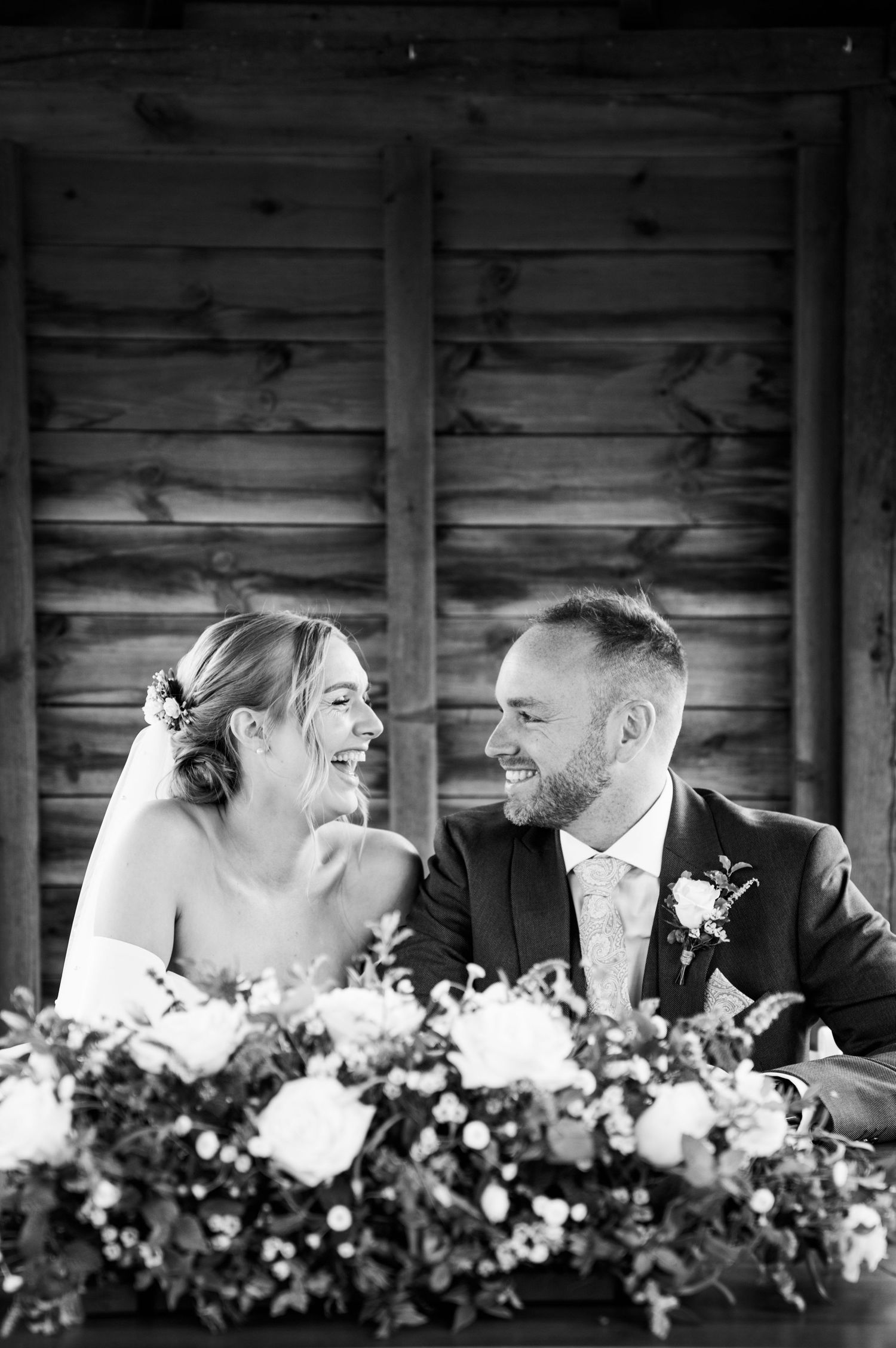 A happy moment shared between a bride and groom. Signing of the marriage certificate. big smiles on their faces. Black and white image.