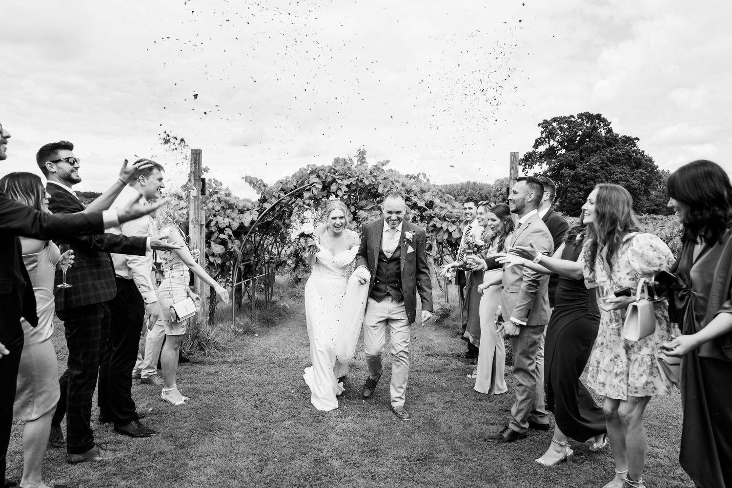 A exciting moment shared with the wedding party as the bride and groom walk down the isle with confetti flying everywhere.