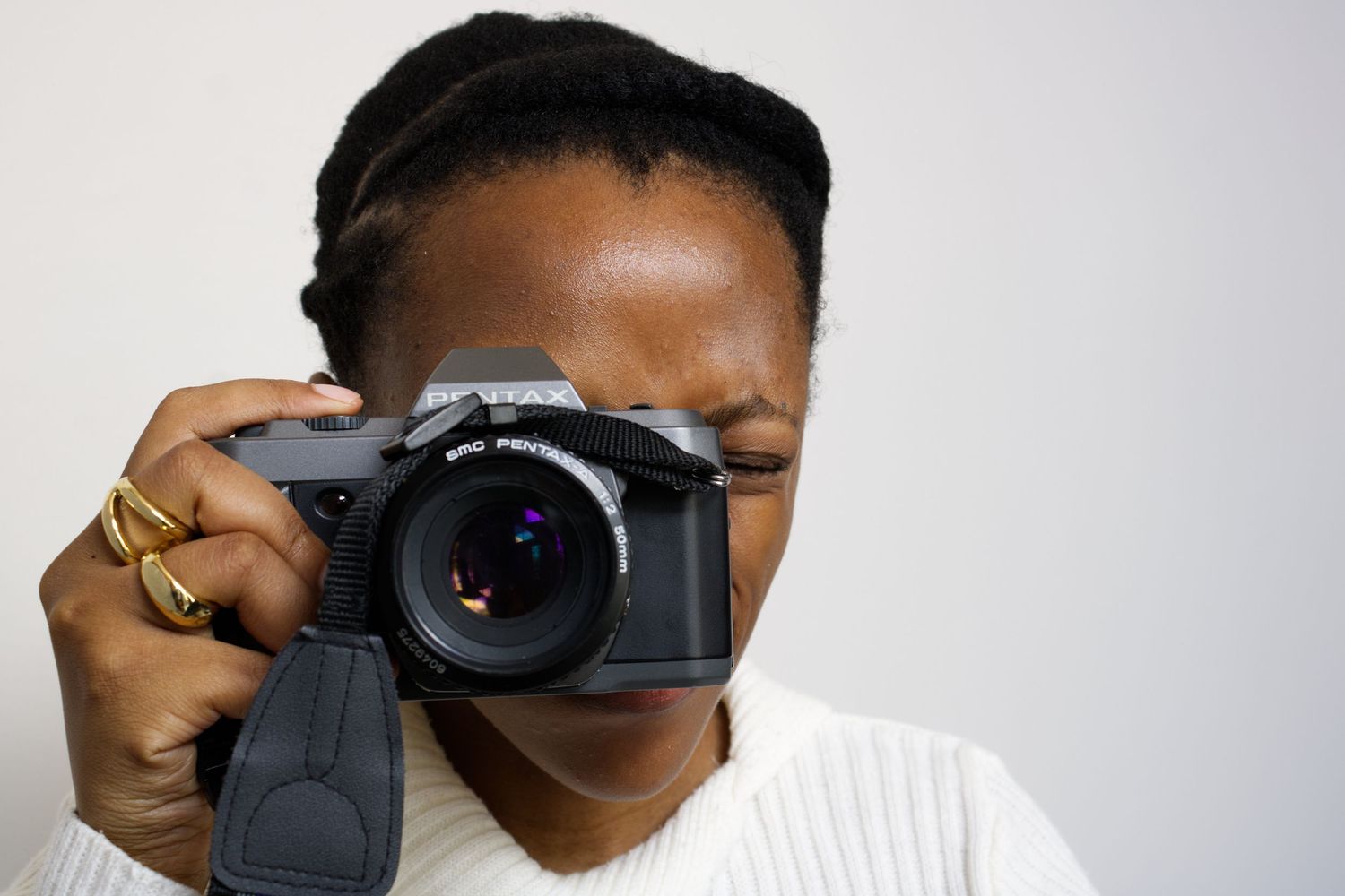 Omphile Onkgopotse, architecture and fine art photographer holding Pentax film camera