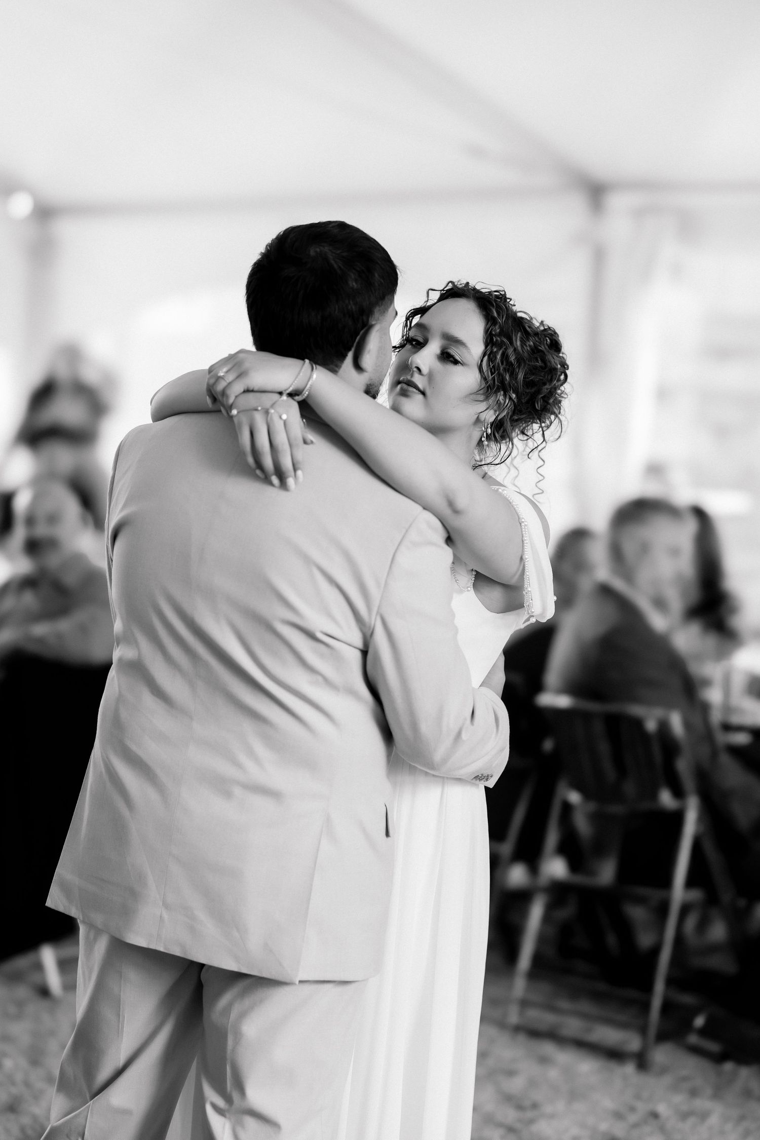 Black and white photo of bride and groom sharing intimate first dance at wedding reception.